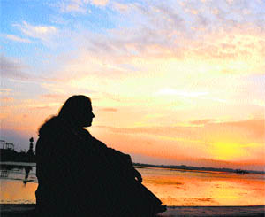 A tourist watches the sunset on the banks of the Dal Lake in Srinagar.