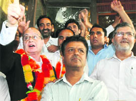 Zaffar Qureshi (garlanded), newly elected president of the Kashmir Bar Association, gestures at his supporters at the Sadar Court Complex in Srinagar on Thursday. 