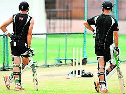 New Zealands Martin Guptill (L) and James Franklin watch their teammates during a practice session on Thursday