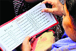 A devotee reads a holy scripture after taking a dip in the Ganga at Brahamkund, Har-ki-Pauri, in Haridwar on Friday