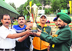 Harbhajan Singh, Director, ITBP Academy, presents the trophy to the winners of the karate championship in Mussoorie on Friday.