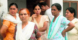 Relatives and neighbours of the girl outside her residence at Idgah Mohalla in the Garha locality in Jalandhar on Friday.