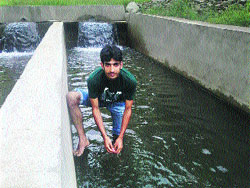Tahir Ahmad Lone (23), a B.Com graduate, at his trout farm.