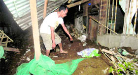A resident sifts through the debris of a collapsed house in Cagayan De Oro city on Friday.