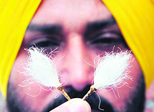 An artist displays a miniature version of 1.25 centimetre small chaur sahib on the Sri Guru Granth Sahib Parkash Utsav in Amritsar.