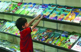 A child checks out books at the 18th Delhi Book Fair that opened at Pragati Maidan in New Delhi on Saturday