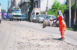 A worker uses construction material on the Janipur-Bantalab road in Jammu on Saturday