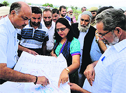 Minister for Higher Education Abdul Gani Malik looks at a chart while inspecting the ongoing construction work of the Jawahar Navodaya Vidyalaya at Karwa village in Reasi on Saturday