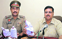 Police officials show heroin seized from three persons in Jalandhar on Saturday