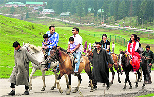 Tourists ride ponies at a tourist spot in Gulmarg.