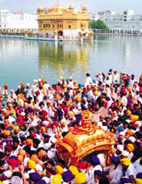 Sikh devotees participate in a procession to mark the 408th anniversary of Guru Granth Sahib at the Golden Temple in Amritsar on Saturday.