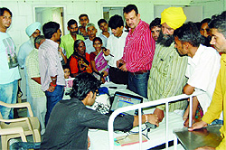 BJP leader Rajinder Mahajan (in red shirt) inquires about problems faced by agency employees in Amritsar