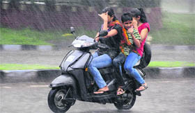 A woman and two children brave heavy showers in Chandigarh on Sunday.