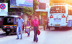 A private bus stops on a slip road of the Jalandhar-Amritsar highway at PAP Chowk to pick and drop passengers, despite directions from the traffic police to not halt the buses