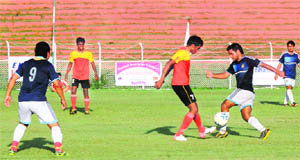 Players of Karnataka and Uttar Pradesh in action during the All Postal Football Tournament at Bakshi Stadium in Srinagar. 