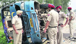 Policemen inspect the site where the bus overturned near Mullanpur on Sunday. 