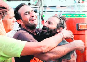 Relatives console the wailing father of the victims