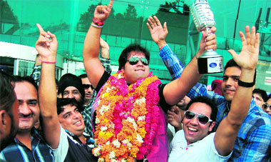 Friends lift Vipul Mehta on their shoulders as he comes out of the airport.