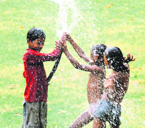 Children play with a water pipe in Karnal. 