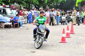 A drivers licence aspirant undergoes a driving test without wearing a helmet at Narwal, Jammu, on Monday