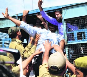 The National Youth Corps volunteers being taken into preventive custody by the police during a protest in support of their demands in Srinagar on Monday