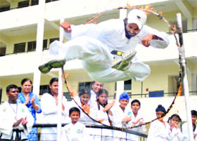 A tae kwon do instructor performs a daring act on the eve of World Tae Kwon Do Day at a school in Patiala.