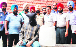 Anil Sharma (with covered face) in the police custody in Amritsar on Tuesday. photo: sameer sehgal 