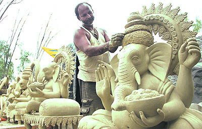 An artist gives final touches to the sculptures of Lord Ganesha ahead of Ganesh Chaturthi in Jalandhar on Tuesday.