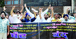 Hoteliers stage a protest outside Jallianwala Bagh in Amritsar on Wednesday
