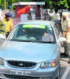 Policemen search a car at gate number 2 of Panjab University.