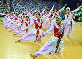 Schoolchildren present their performance on the occasion of Teachers Day at Tyagraj Stadium in New Delhi on Wednesday