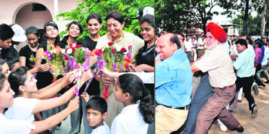 Principal, The Heritage School, P Gill being greeted by students on the occasion of Teachers' Day in Dehradun on Wednesday; and (right) a tug of war in progress between teachers and students at Summer Valley School. 