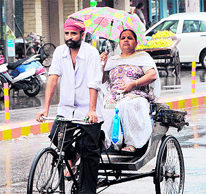 A woman uses an umbrella as rain lashes Amritsar on Wednesday
