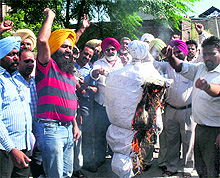 Government teachers burn an effigy of the Education Minister outside the DEOs office in Jalandhar on Wednesday