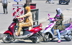 Girls drive scooters without halmet in Srinagar. A tribune photograph