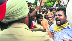 Garbage collectors argue with a policeman during a protest at Bharat Nagar Chowk on Wednesday. Tribune photo: Himanshu Mahajan 