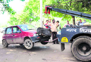 MC officials tow away a vehicle from the motor market, Sector 48, in Chandigarh on Thursday.