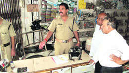 Police officials examine a shop, which was burgled at the Saharanpur chowk, in Dehradun on Thursday.