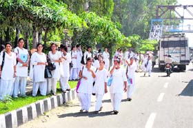 Students wait for a bus on the roadside in Jammu