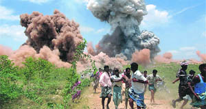 People flee as clouds of smoke billow out after a devastating blaze on the outskirts of a fireworks factory in Sivakasi in Tamil Nadu. 