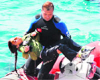 A diver carries a girl after a boat carrying illegal immigrants capsized off Turkeys western coast.  AFP