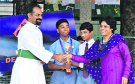 Principal of St Joseph's Academy Brother AJ George congratulates the winning team of the Bournvita Quiz Regional Competition in Dehradun on Friday. 