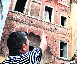 City Magistrate Jeevan Singh Nambiyal points towards cracks in 100-year old Barah Kothi at Pahadi Bazaar in Kankhal during an inspection of dilapidated buildings in Haridwar on Friday.