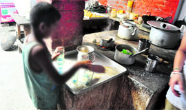 Even as the world celebrates International Literacy Day, a child labourer collects empty glasses at a canteen in Ludhiana. 