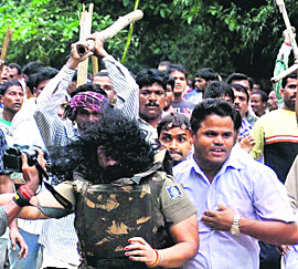 Woman cop being chased away by Cong workers.