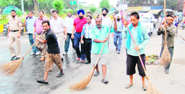 Workers of the Municipal Corporation clean a road as part of special cleanliness drive in Amritsar on Saturday.