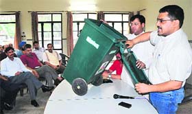 Commissioner VP Singh shows a dustbin to be distributed under garbage collection scheme at the Kendriya Vihar Society, Sector 48, in Chandigarh on Saturday