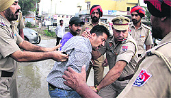 Policemen prevent a Congress activist from gheraoing Local Bodies Minister Bhagat Chunni Lal during the foundation stone-laying function of a bridge near Leather Complex in Jalandhar on Saturday