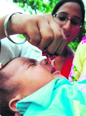 A health worker administers polio drops to a child in Amritsar on Sunday. 