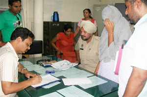 A doctor prepares the medical report of Namdeek Kaur, Gurshaheed Singh Sheras girlfriend, at the Civil Hospital in Bathinda on Sunday.